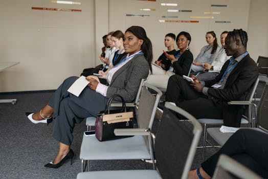 A diverse group of adults engaged in a business seminar, showcasing active listening and participation.